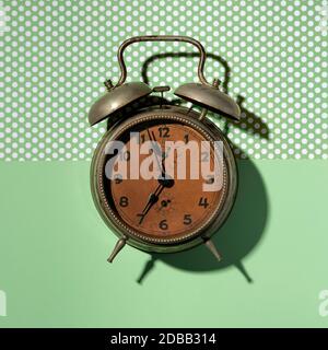 Vintage alarm clock on green background Stock Photo