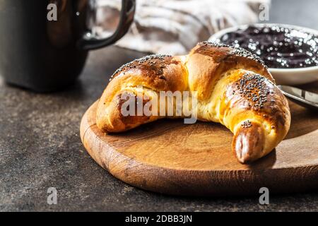Sweet homemade croissants with poppy on kitchen table. Stock Photo