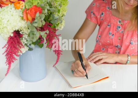 Woman writing in notepad Stock Photo