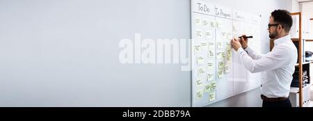 Executive Writing Kanban Plan And Schedule On Whiteboard Stock Photo