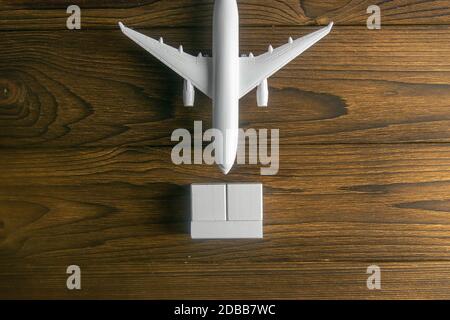 Airplane with wooden cubes on which you can enter your date stands on a wooden table. Top views Stock Photo