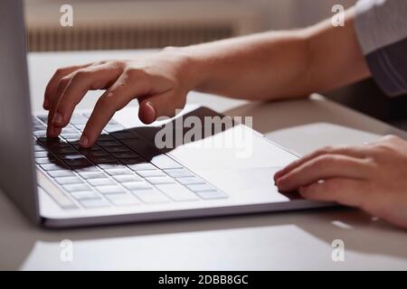 Close-up of boys (8-9) hands typing on laptop Stock Photo