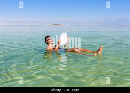 Man relaxing in nature.. View of Dead Sea coastline. Salt crystals at sunset. Texture of Dead sea. Salty sea shore Stock Photo