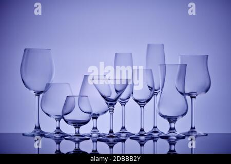 Set of glasses for different alcoholic drinks and cocktails on light gray background. Empty clear glassware. Stock Photo
