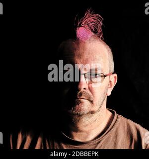 Male with mohawk hair in pink - London, United Kingdom Stock Photo