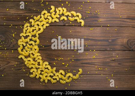 Pasta di Pene lisce a forma di cerchio su sfondo di legno scuro. Vista  frontale Foto stock - Alamy