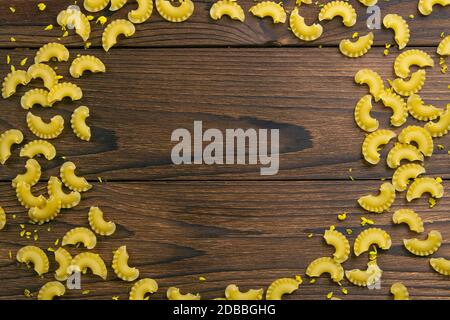 Pasta di Pene lisce a forma di cerchio su sfondo di legno scuro. Vista  frontale Foto stock - Alamy