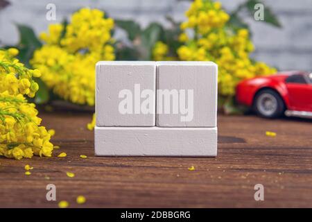 White wood calendar blocks for write the date and branches with yellow flowers over a wooden table. Selective focus with blurred background. Stock Photo