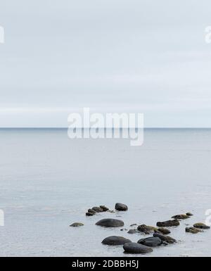 Minimalist image of the Giant's Causeway in Northern Ireland, with rocks in the foreground and the calm sea in the background Stock Photo