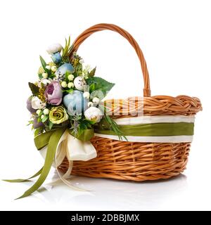 Handmade easter basket in vintage style decorated with flowers, Easter eggs and wide ribbons. Isolated on white background. Stock Photo