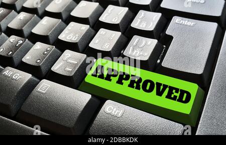 Black keyboard with one green key labeled by approved sign. Stock Photo