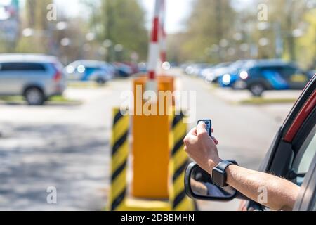 lifting the barrier in the parking lot with the help of remote control Stock Photo