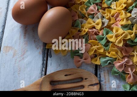 dry pasta on rustic wood and fresh eggs Stock Photo