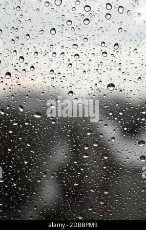 Drops of rain on the window, rainy day, dark tone. Shallow DOF Stock Photo