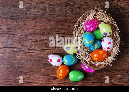 A basket with straw on wood with toy easter eggs and copy space Stock Photo