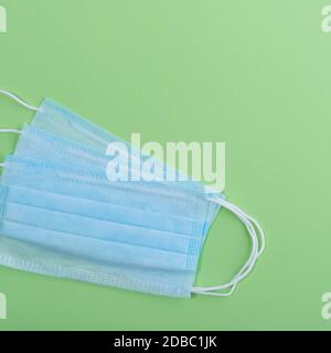 Medical mask surgical protective virus, flu, disease, textile filter. Isolated on a green background. Stock Photo