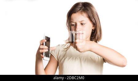 angry little girl holding a smartphone with broken screen in studio Stock Photo