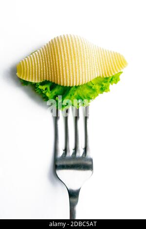 Conchiglie pasta with lettuce on a fork isolated against white. Stock Photo