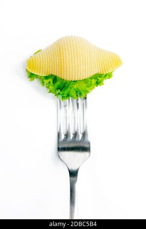 Conchiglie pasta with lettuce on a fork isolated against white. Stock Photo