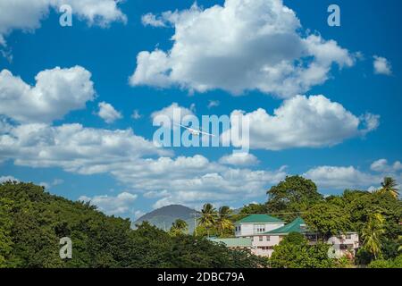A twin propeller plane taking off over a tropical paradise Stock Photo