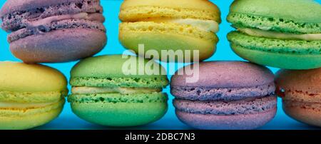 multi-colored round baked macarons cakes on a  blue background, banner Stock Photo