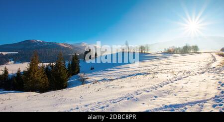 mountainous rural landscape in wintertime. wonderful frosty sunny day. trees on the snow covered hills. Stock Photo
