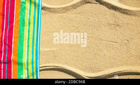 Beach towel photographed from above on sandy beach with copy space, hot summer day, vacation destination Stock Photo