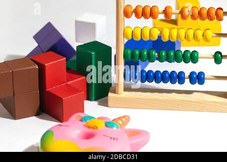 Children toys wooden colorful blocks, abacus and toys antistress donut unicorn on white Stock Photo