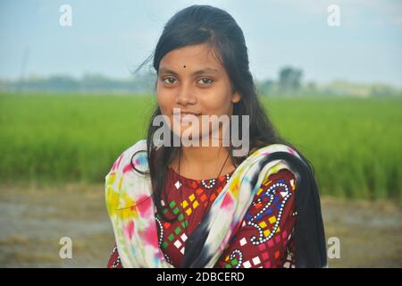 Close up of a beautiful teenage Indian Bengali girl wearing colorful salwar kameez with a golden nose pin and black bindi on her forehead. Stock Photo