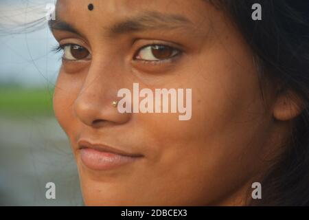 Close up of a beautiful girl with a golden nose pin and black bindi on her forehead, selective focusing Stock Photo