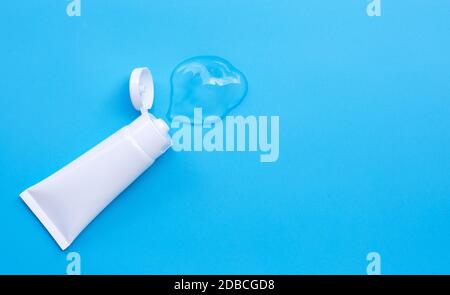 Clear gel in white glossy plastic tubes on blue background with copy space Stock Photo