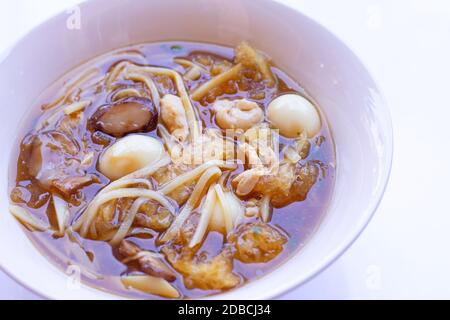 Braised fish maw in red gravy in bowl on white background. Stock Photo