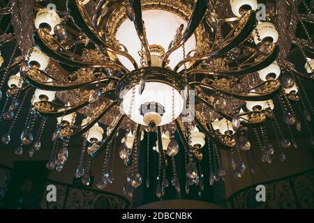 A low angle view of a fancy Chandelier with the lights on with a blurry background Stock Photo