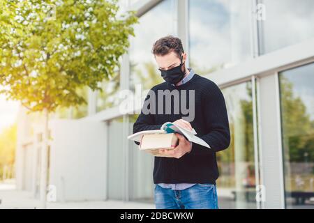 Student wearing mask during covid-19 cannot enter closed university building Stock Photo