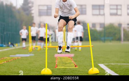 Footballers on Practice Session in Field on Sunny Day. Soccer Player on Fitness Training. Young Soccer Players at Speed and Agility Practice Training Stock Photo