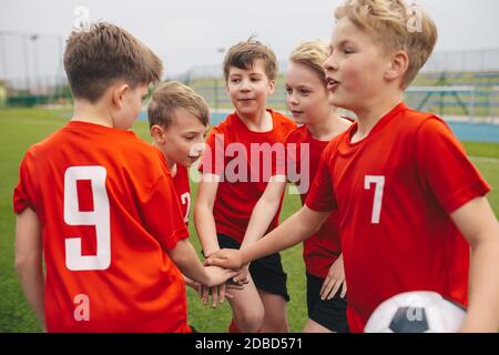 Happy Kids Sports Team Stacking Hands At The Field. Children Team ...