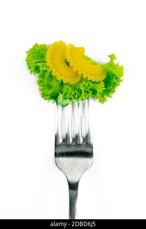 Farfalle pasta with lettuce on a fork isolated against white. Stock Photo