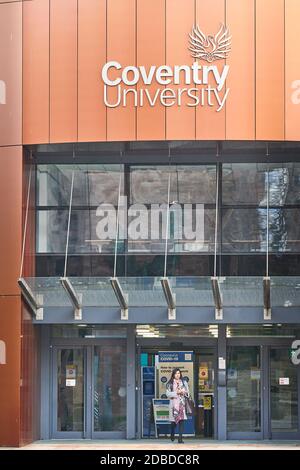 A student stands at the entrance and exit to and from the Alan Berry building (which houses the vice chancellor's office) at the university of Coventr Stock Photo