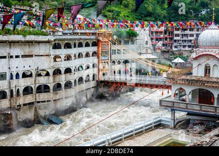 Sikh Gurdwara, bridge over Parvati river and hot springs in Manikaran Sikh sacred site in Himalayas. Himachal Pradesh, India Stock Photo