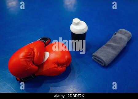 Pair of red boxing gloves, workout pads and equipment on ring canvas, top view, nobody. Box or kickboxing sport concept, training tools, fighting mart Stock Photo