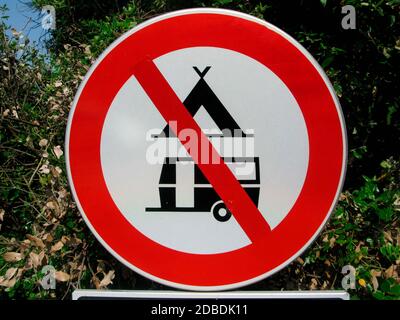 prohibition of camping road sign, circle with crossed out tent and camping van Stock Photo