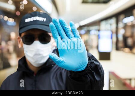 Security Guard Making Stop Hand Gesture In Shopping Mall Stock Photo