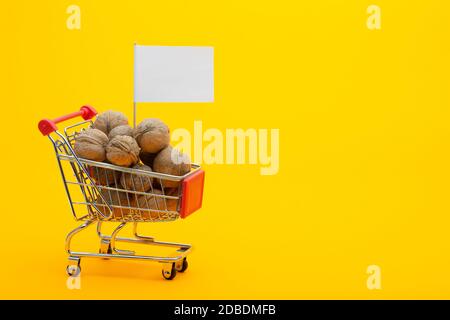 Walnuts are in the grocery cart, a flag with a white price tag is stuck Stock Photo