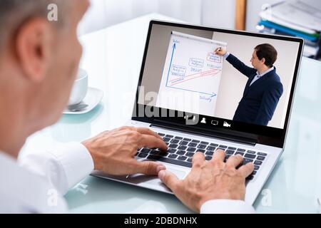 Man Participating In Online Coaching Session Using Laptop Stock Photo