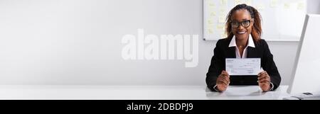 African American Boss Holding Paycheck Or Payroll Check Stock Photo