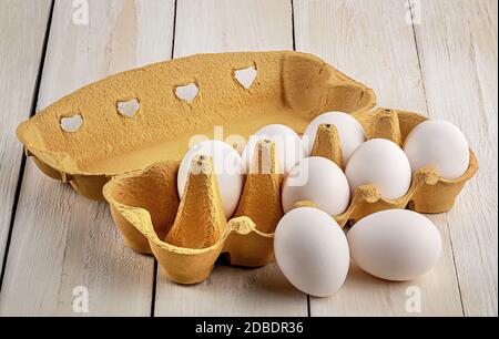 White eggs near paper tray on white table Stock Photo