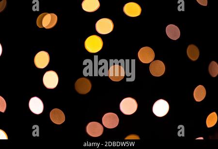 Bright bokeh from christmas garlands on dark background. New year or Christmas backdrop. Stock Photo