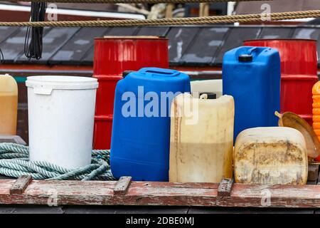 Various plastic cans with chemicals and fuel in a ship harbor Stock Photo
