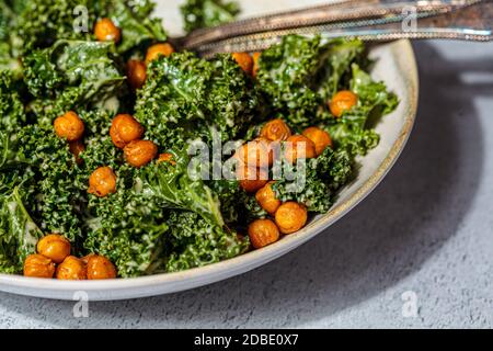 Vegan caesar salad. Fried chickpea salad with kale in a white bowl. Vegan food concept. Stock Photo