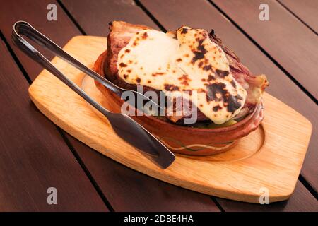Served baked pork knuckle with cheese sauce on table. Stock Photo